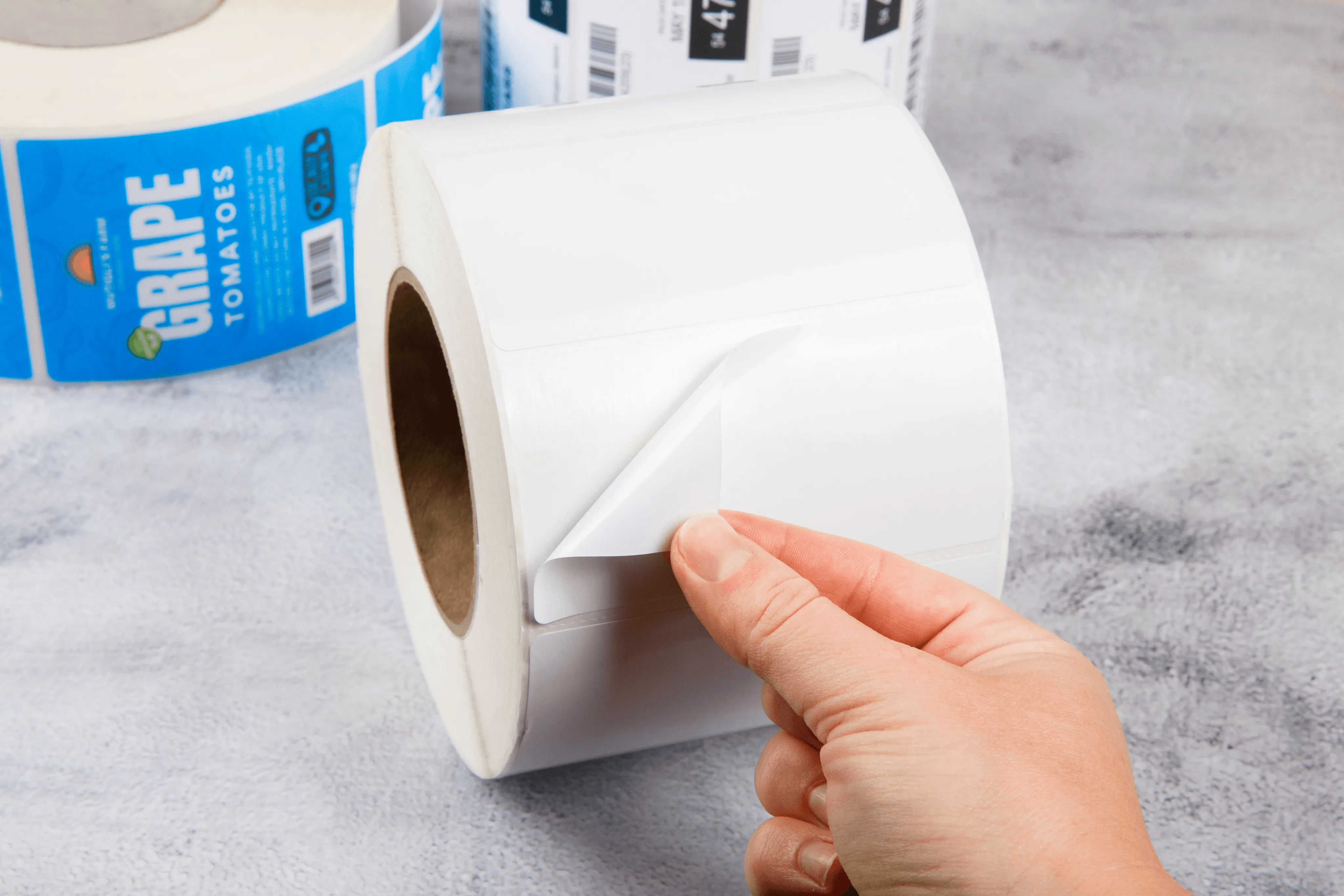 hand peeling white agriculture and natural products labels from a roll