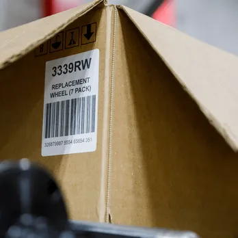 Stack of cardboard shipping boxes with white product labels