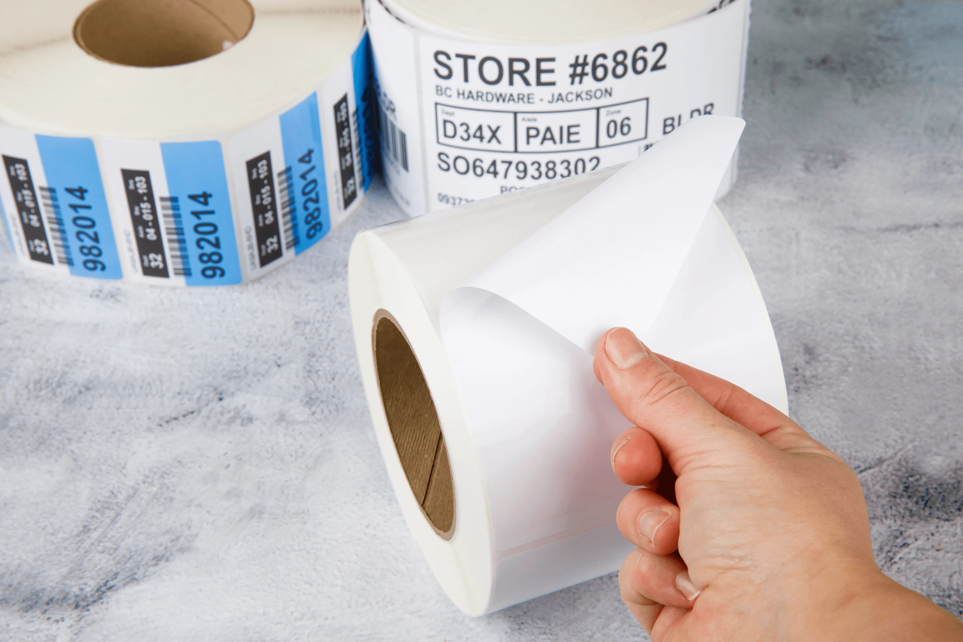 hand peeling white construction and building materials labels from a roll