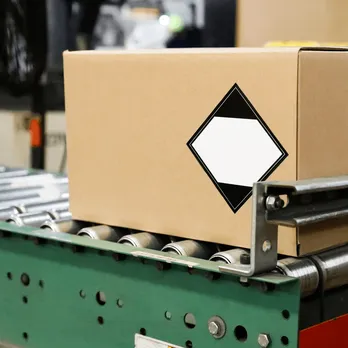 Conveyor belt system transporting brown cardboard boxes in warehouse facility