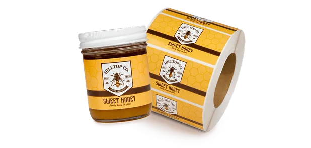 a labeled jar of honey next to a roll of labels