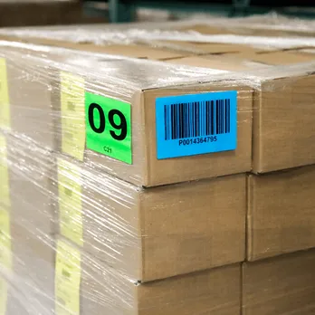 Stacked cardboard boxes with green shipping label showing number 09 and barcode