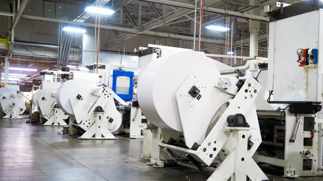 A wide view of several large manufacturing machines in a plant factory setting