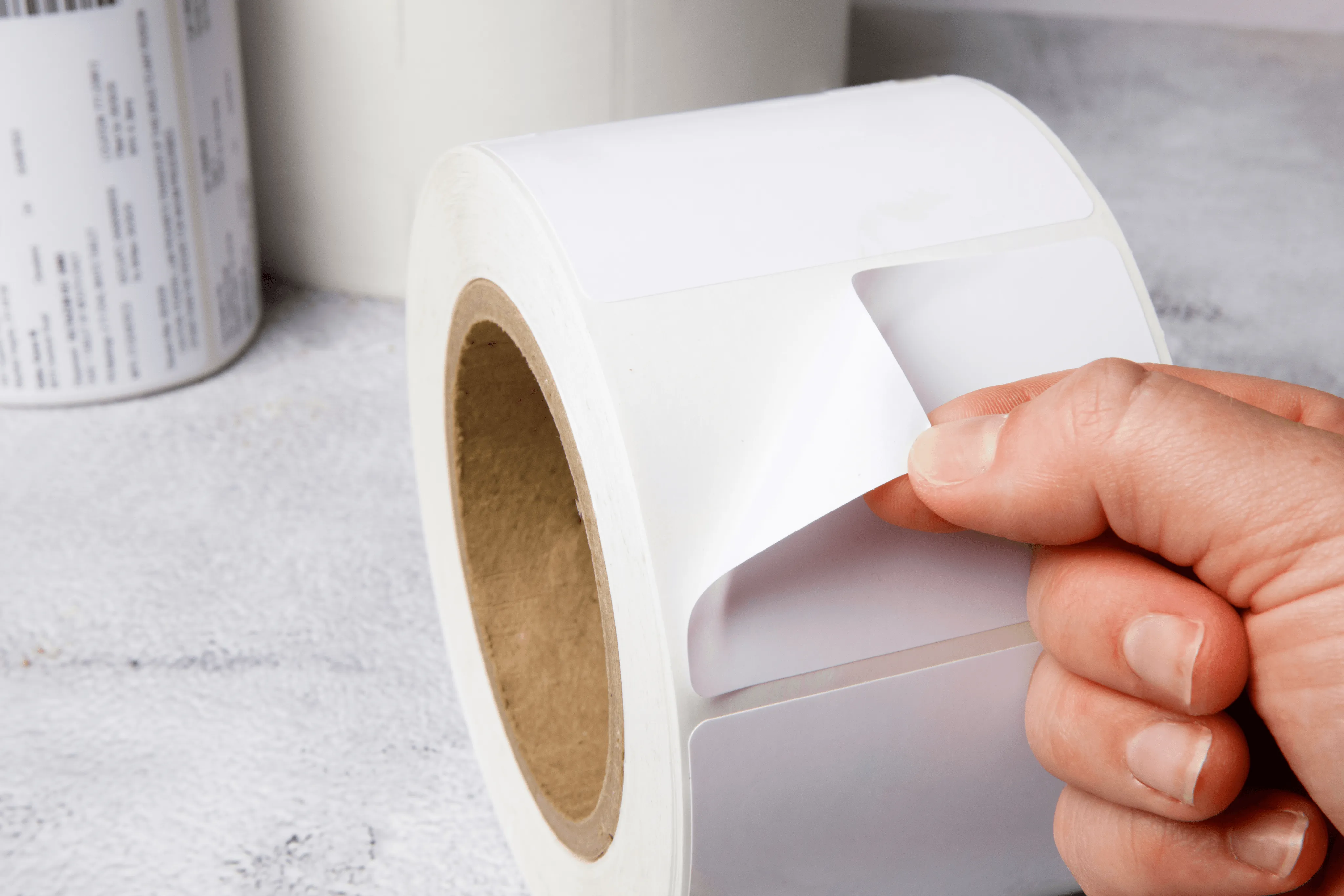 hand peeling white medical labels from a roll