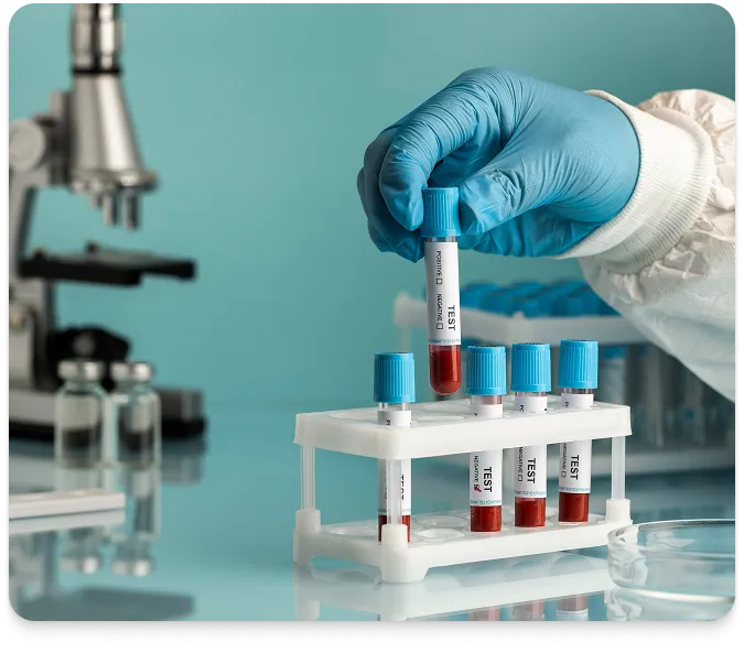 a gloved hand lifting a vial out of a rack with a microscope in the background