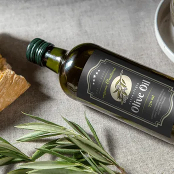 Dark glass olive oil bottles with elegant labels and fresh herbs