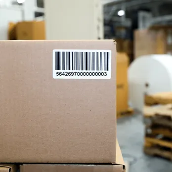 Brown cardboard package with black and white barcode shipping label attached