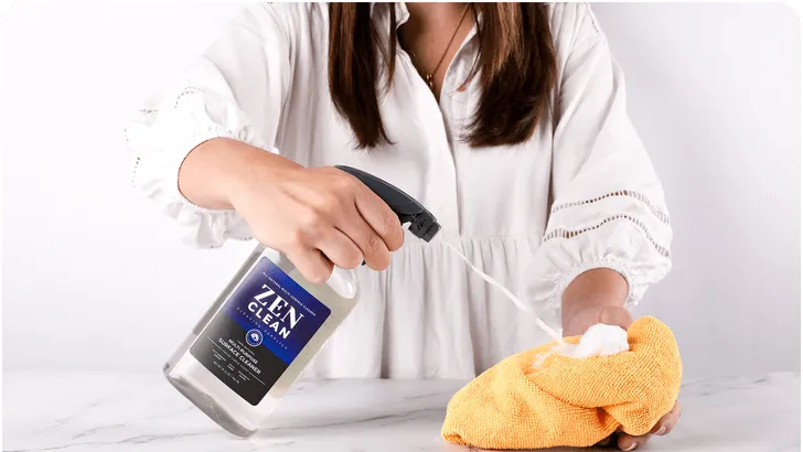 a person spraying a spray bottle into a rag