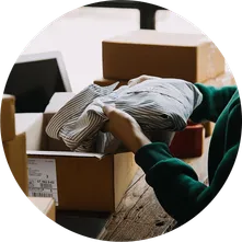 hands lifting a shirt out on a cardboard box