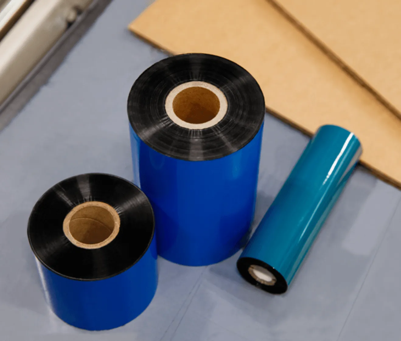 thermal transfer ribbons in black and blue colors laid out on white surface