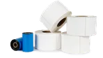 a stack of rolls of labels next to two thermal ribbons