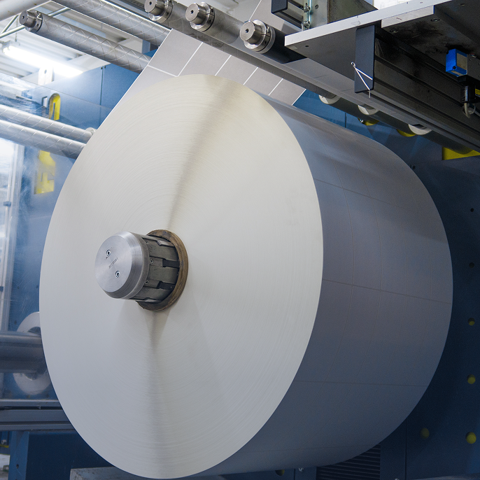 a huge roll of paper on a machine in a factory